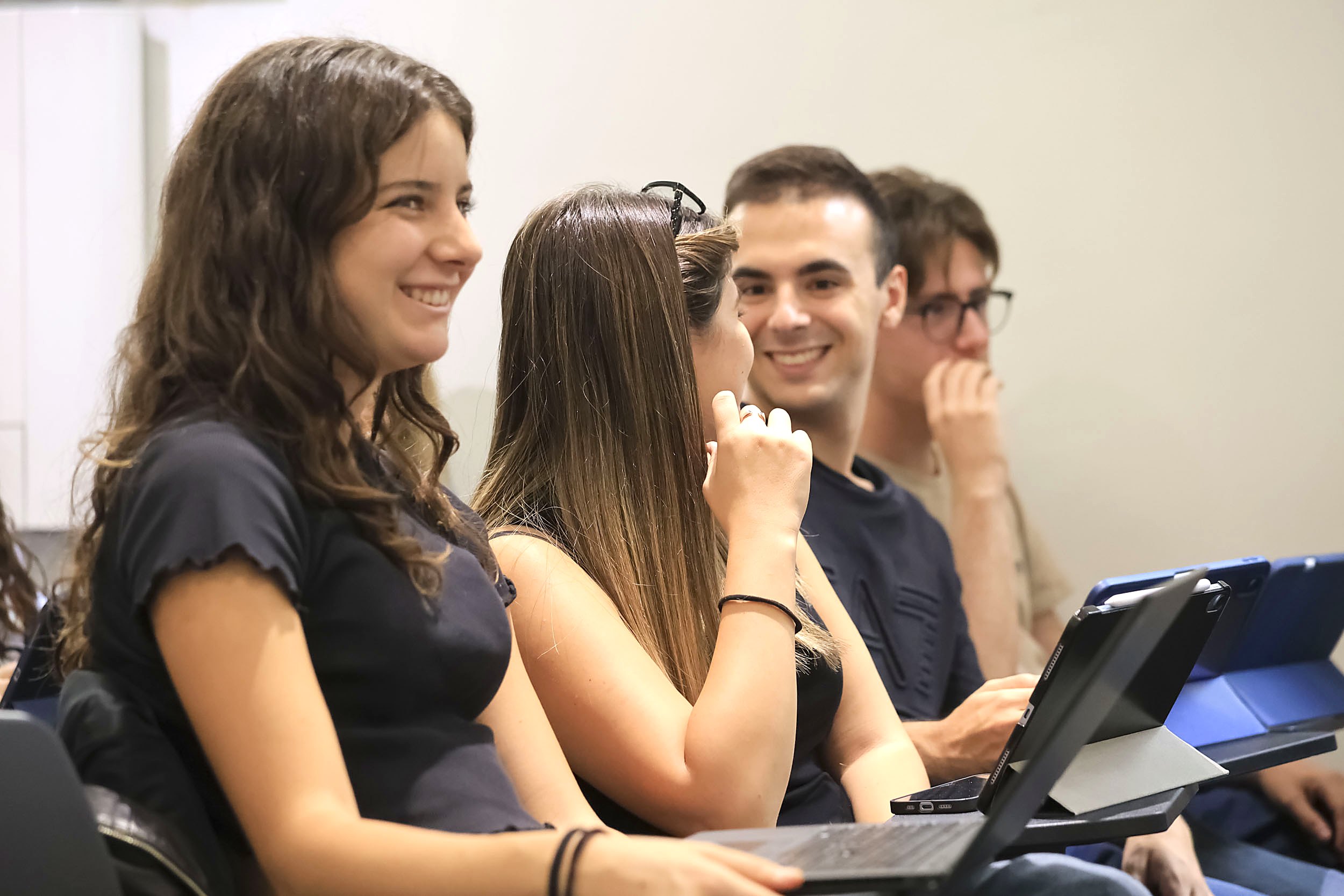 Students smiling during a class at the Unicollege campus in Turin