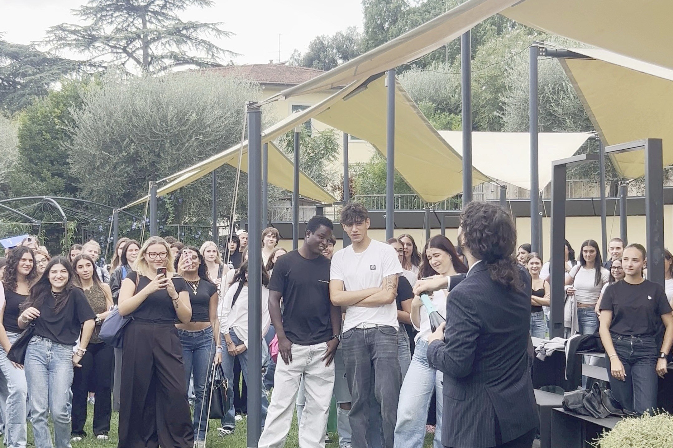 Students gathered under the canopies in the garden of the Florence campus