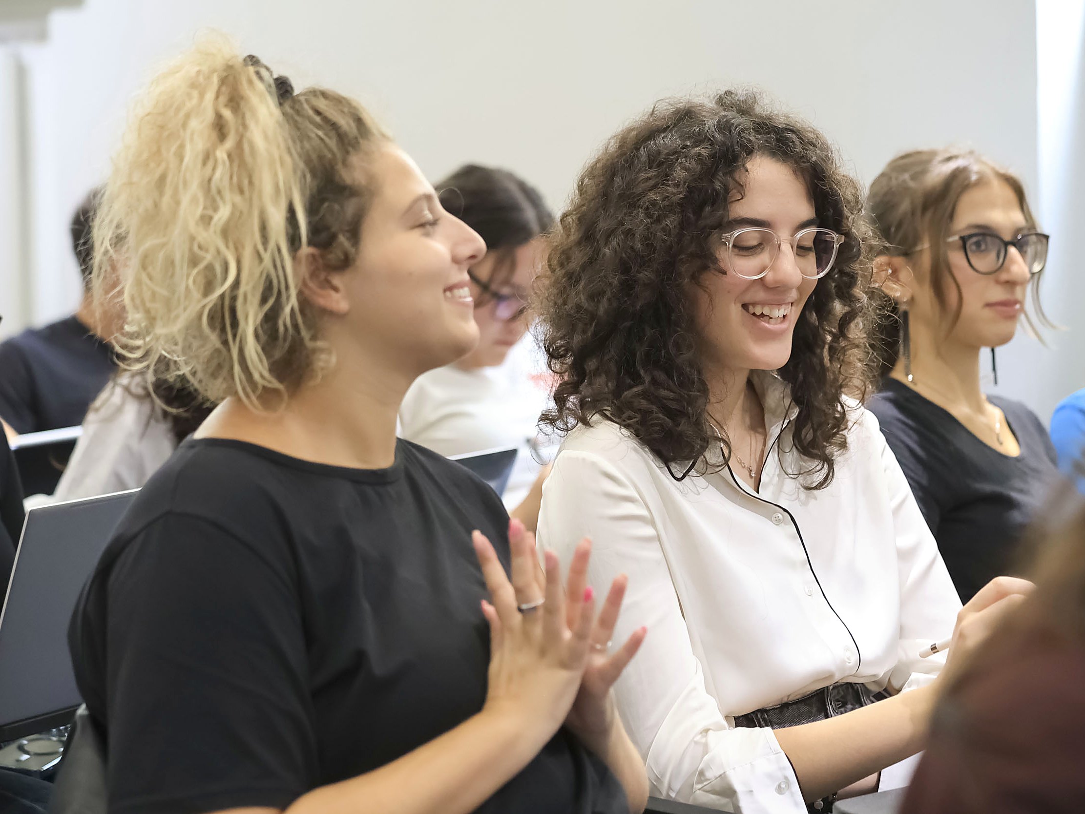Two first-year students laughing together during a class on the Turin campus