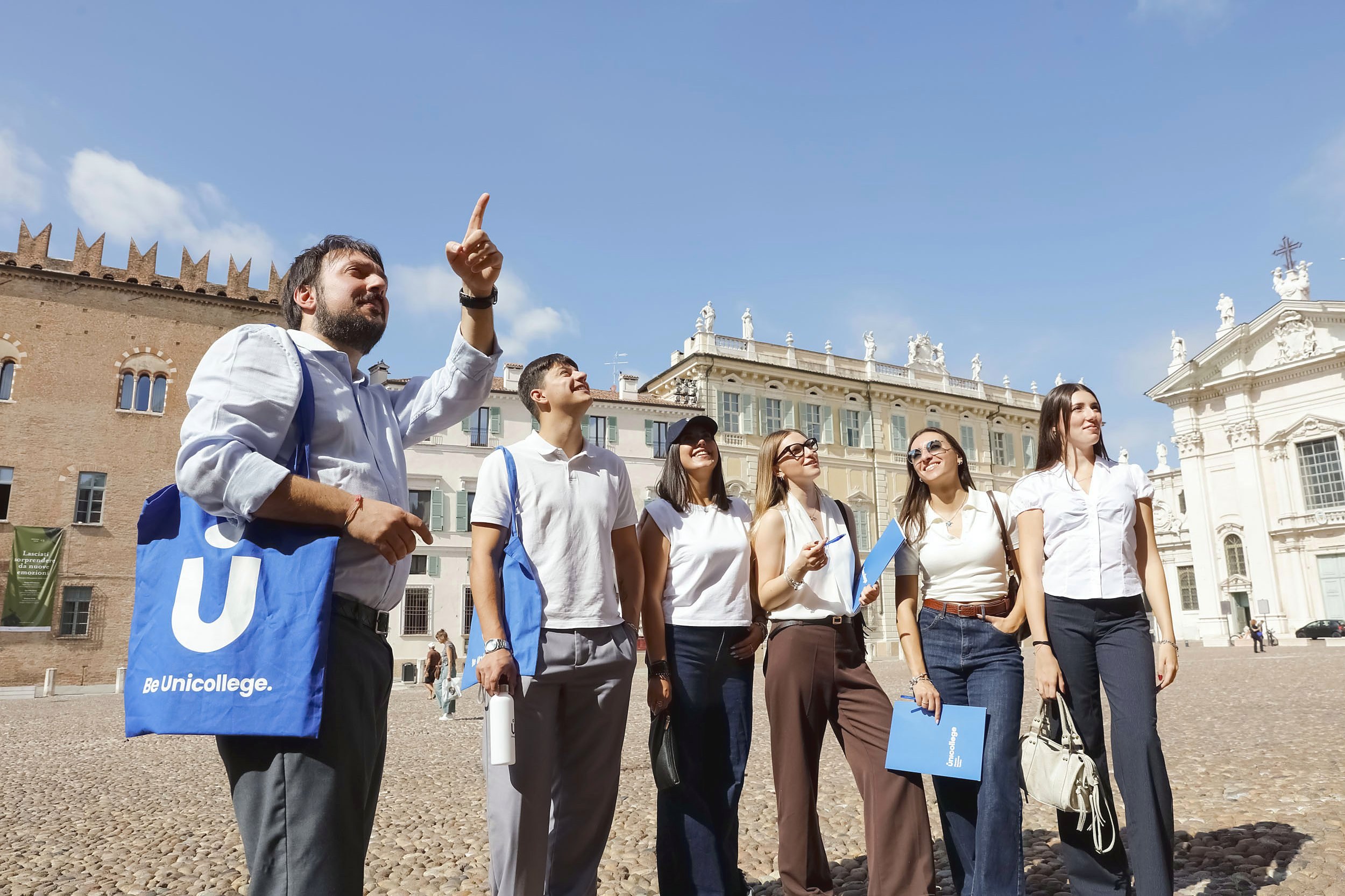 A faculty member guiding his students through Piazza Sordello in Mantua