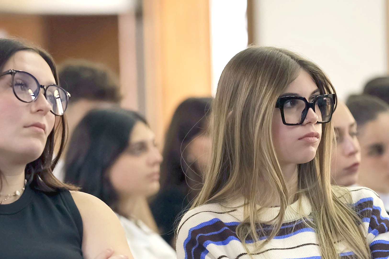 Two students following a talk in the aula magna of Mantua