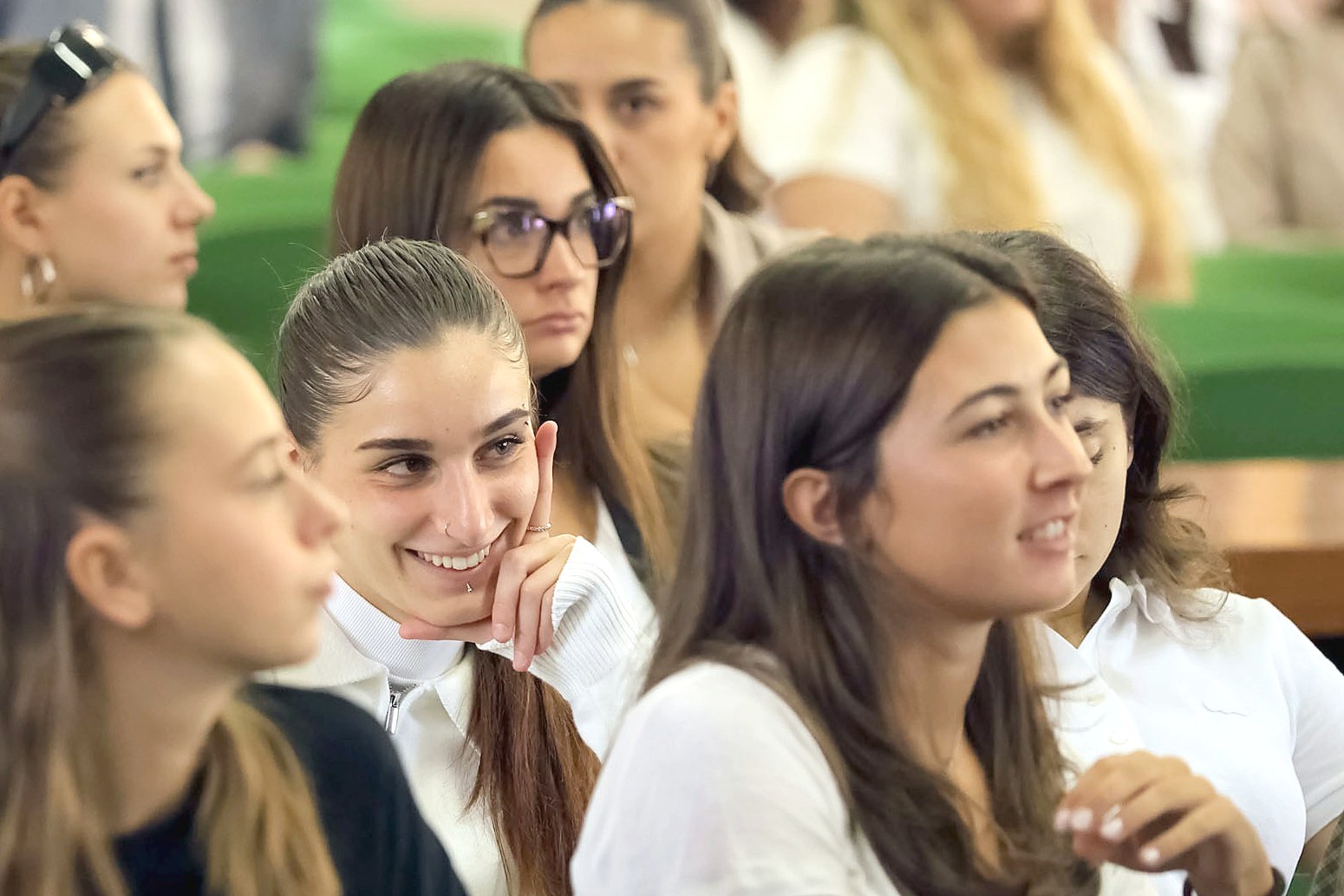 Students smiling during an event in the aula magna of Mantua