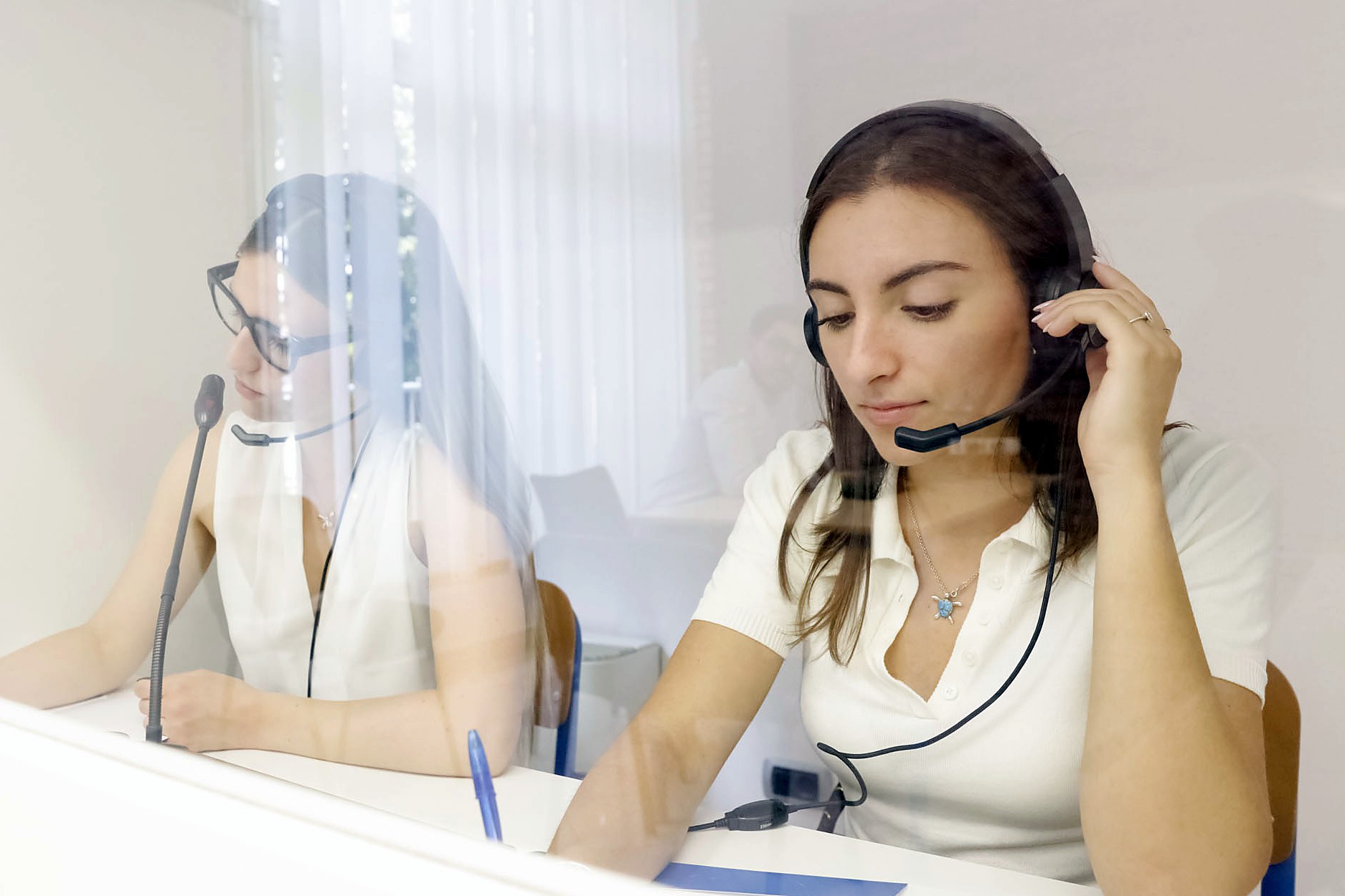 A student practising in the interpreting booth of the Mantua campus