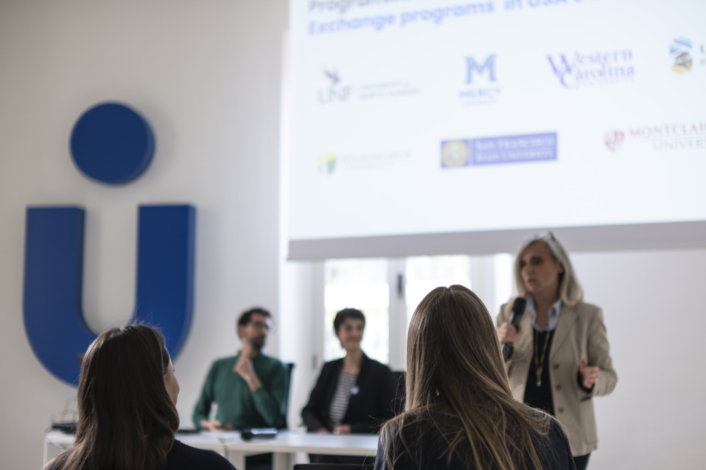 A presentation on exchange programs showing the logos of partner universities