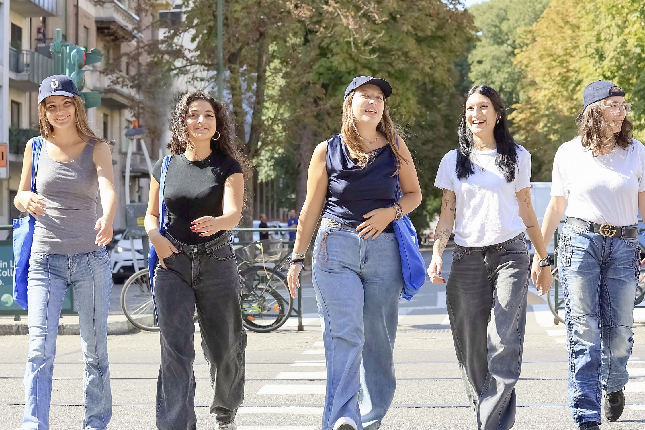 Young students laughing as they cross a street together in Turin