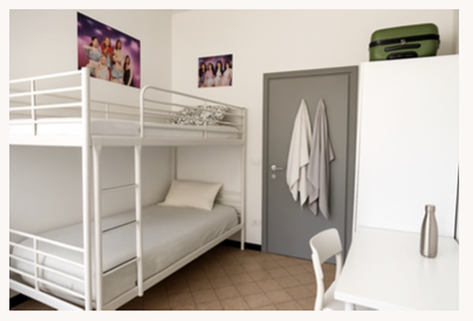 A shared residence room with bunk beds and a study desk