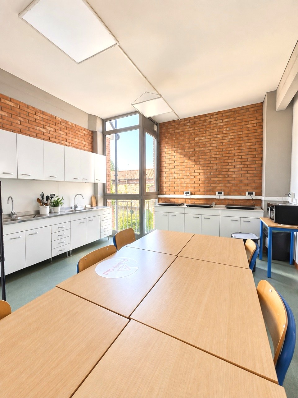 The common room of a residence with kitchen and shared tables