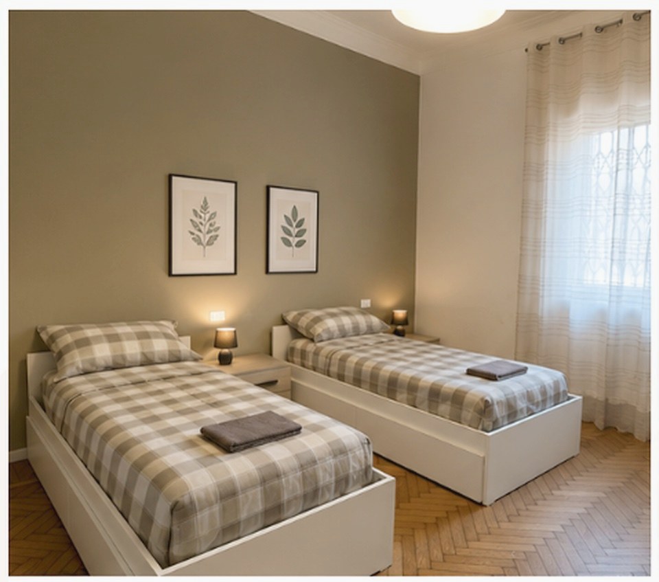 A twin room in a residence with checked linen