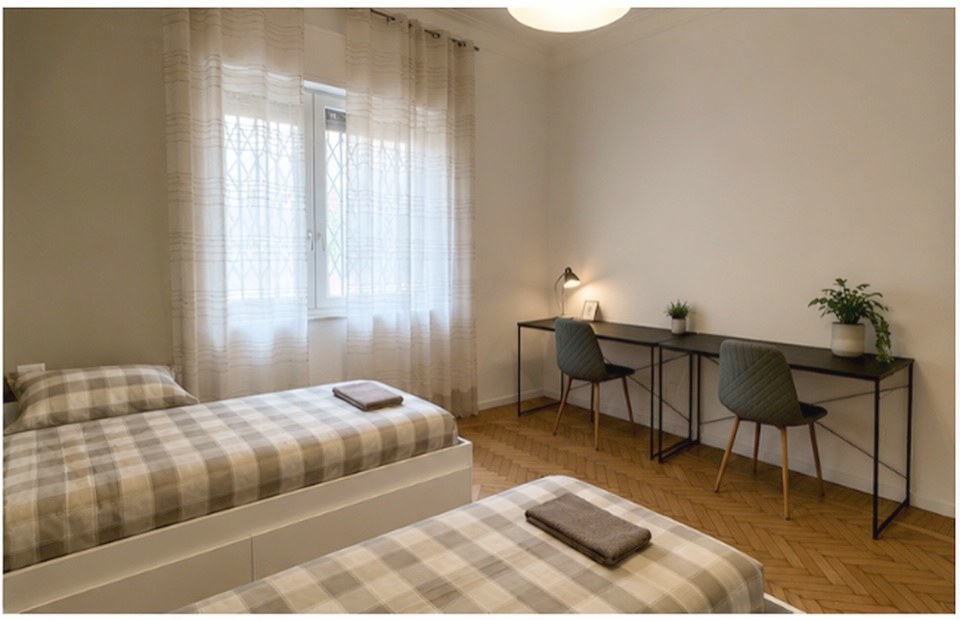 A twin room with two study desks by the window