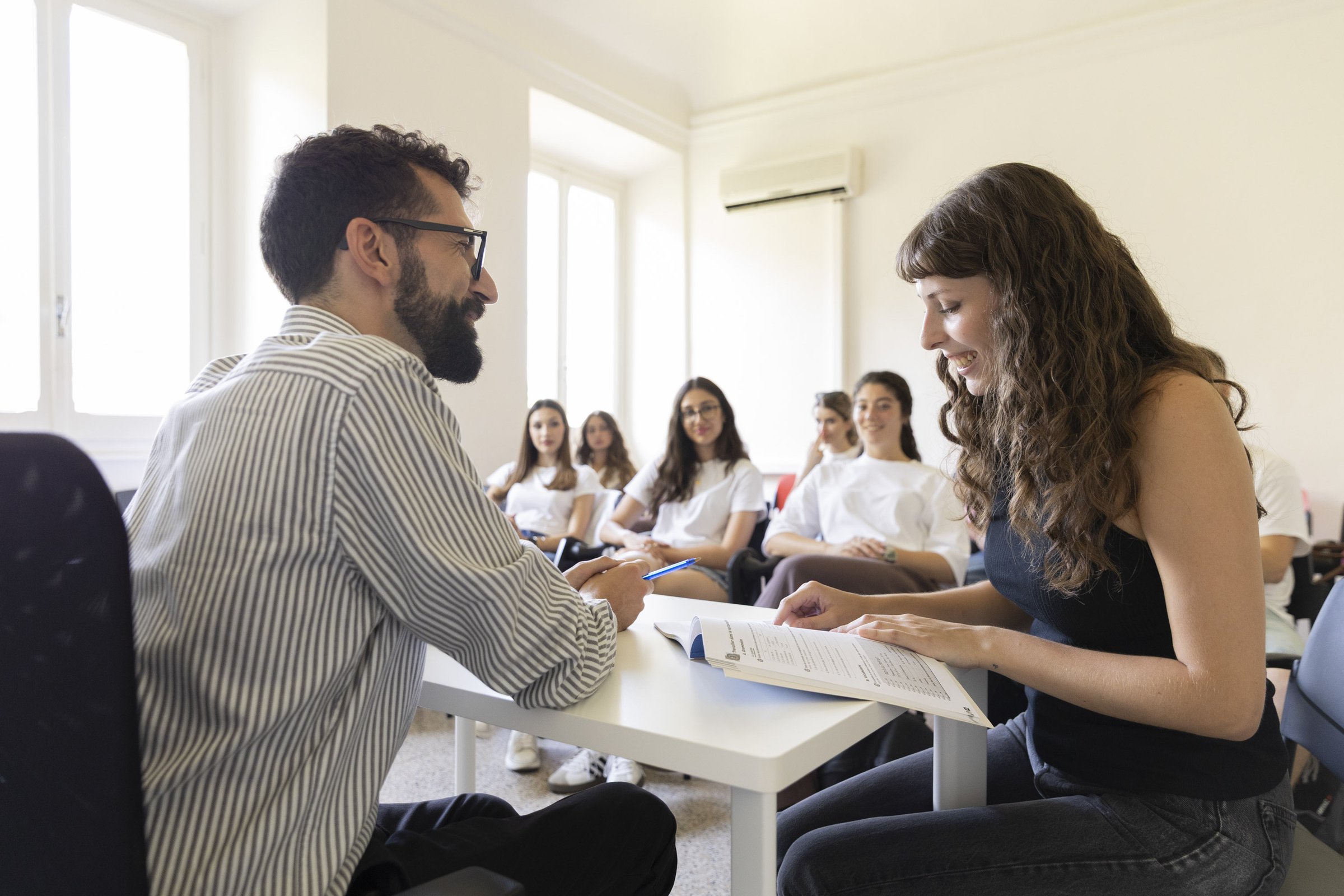 A faculty member leading a placement review with students around the tables