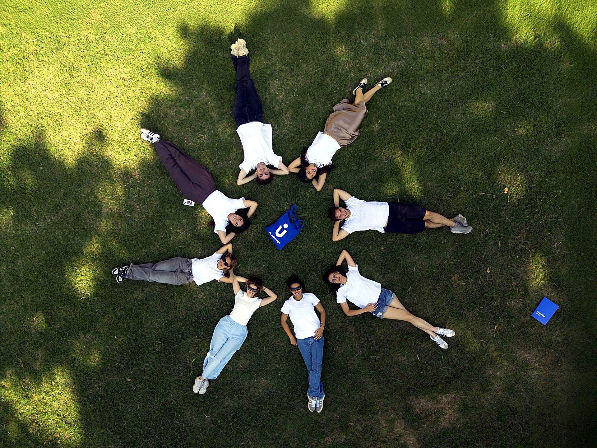 Students lying in a circle on the lawn of the Florence campus