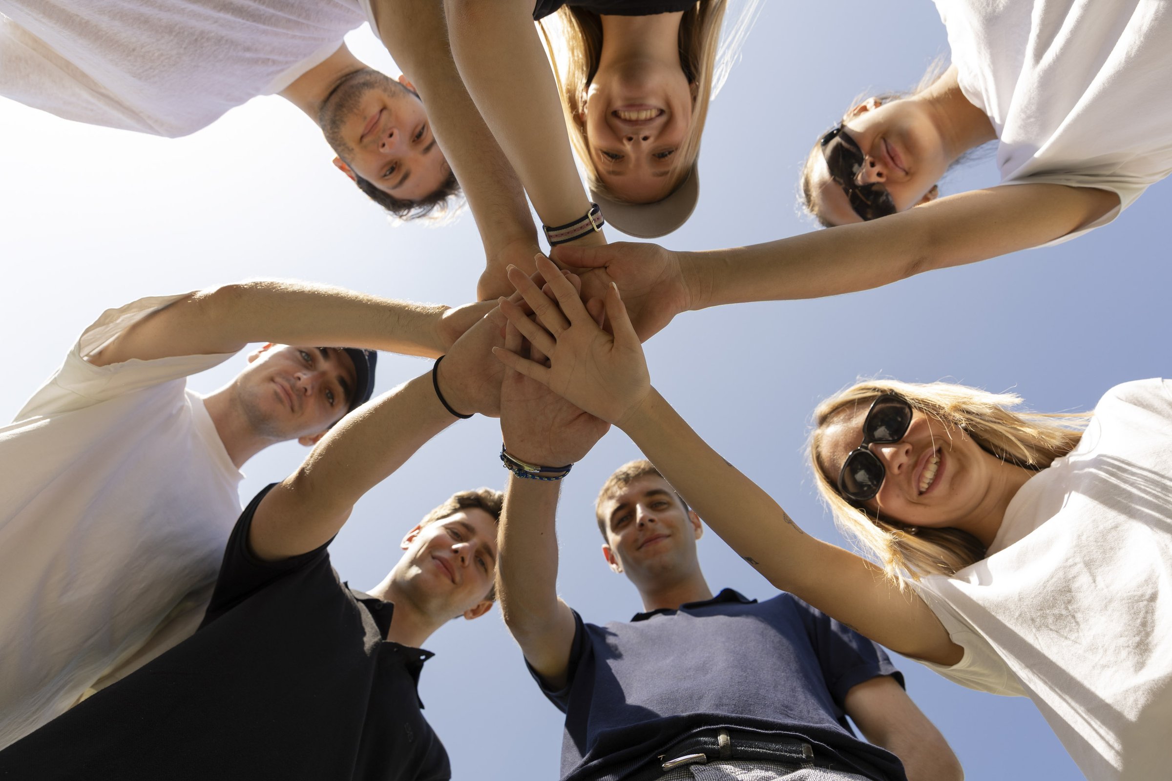 Students joining hands in a circle, seen from below
