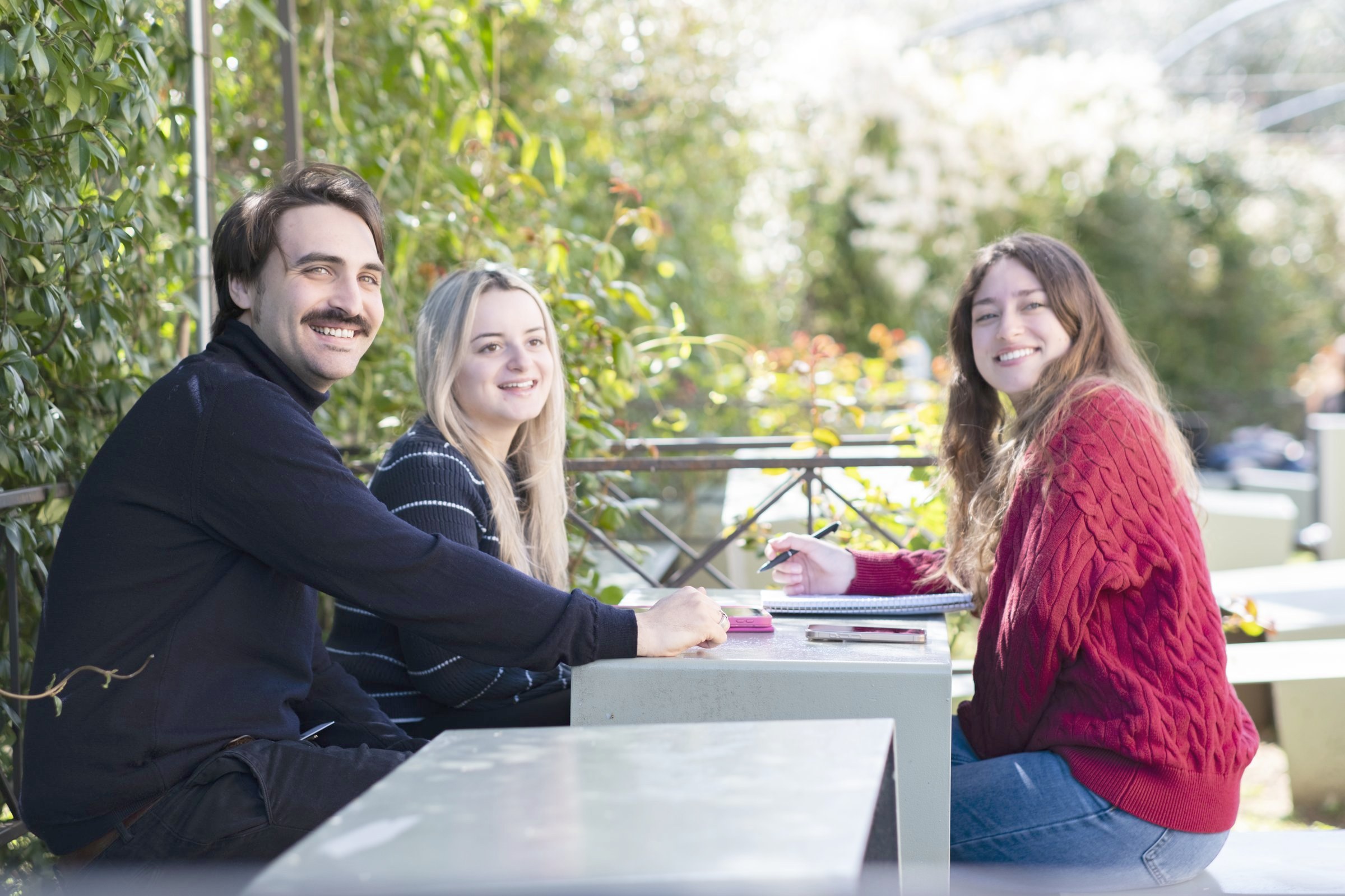 Students talking at the outdoor tables beside Unicafe