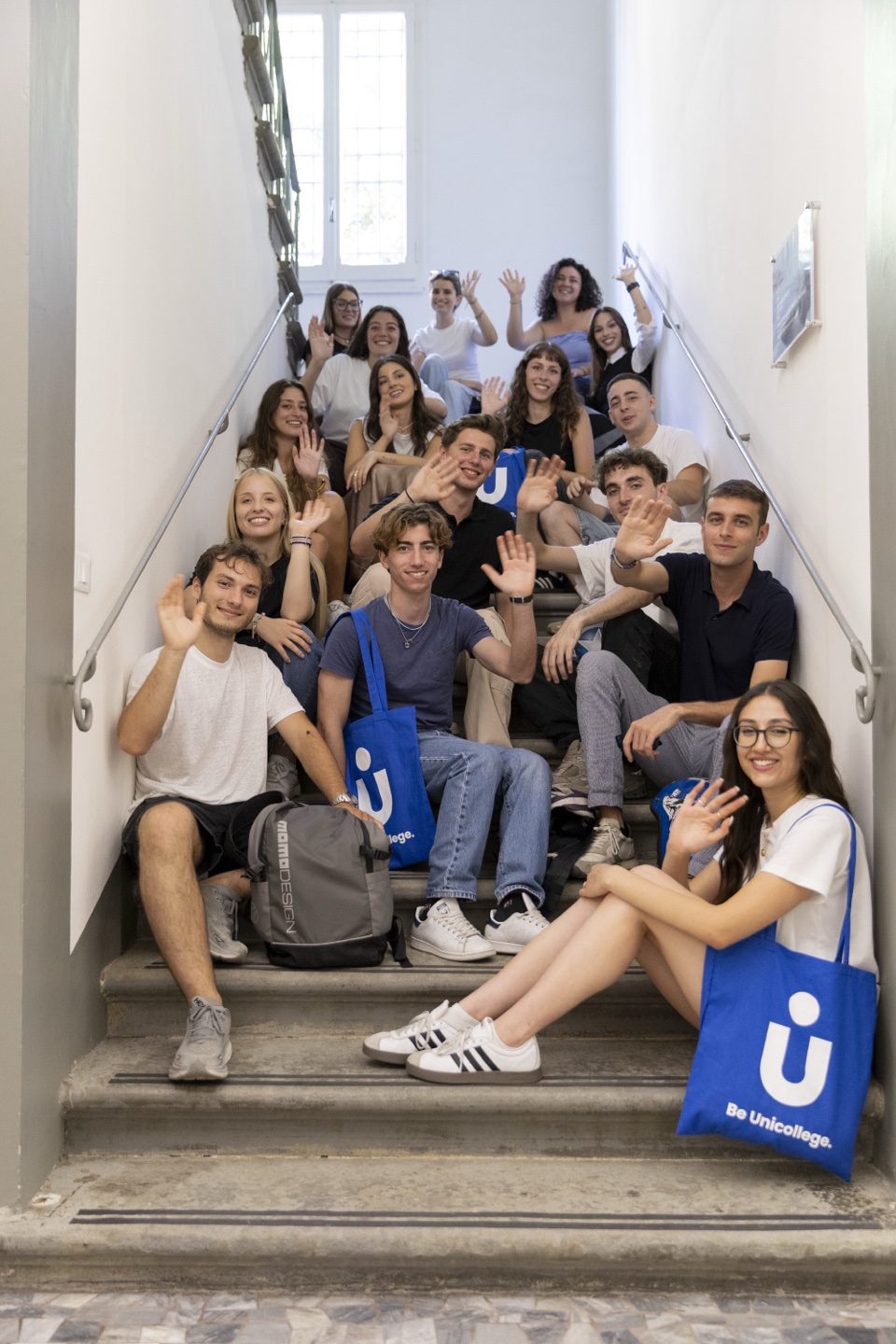 A group of students on the staircase, one with a Unicollege bag