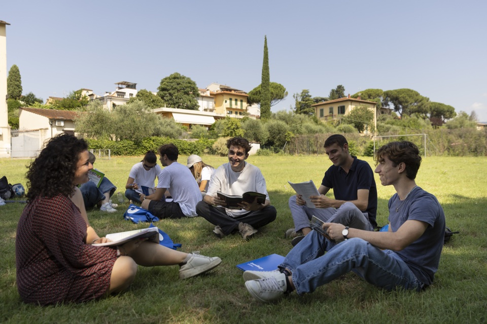 Students studying together on the lawn with the hillside behind them