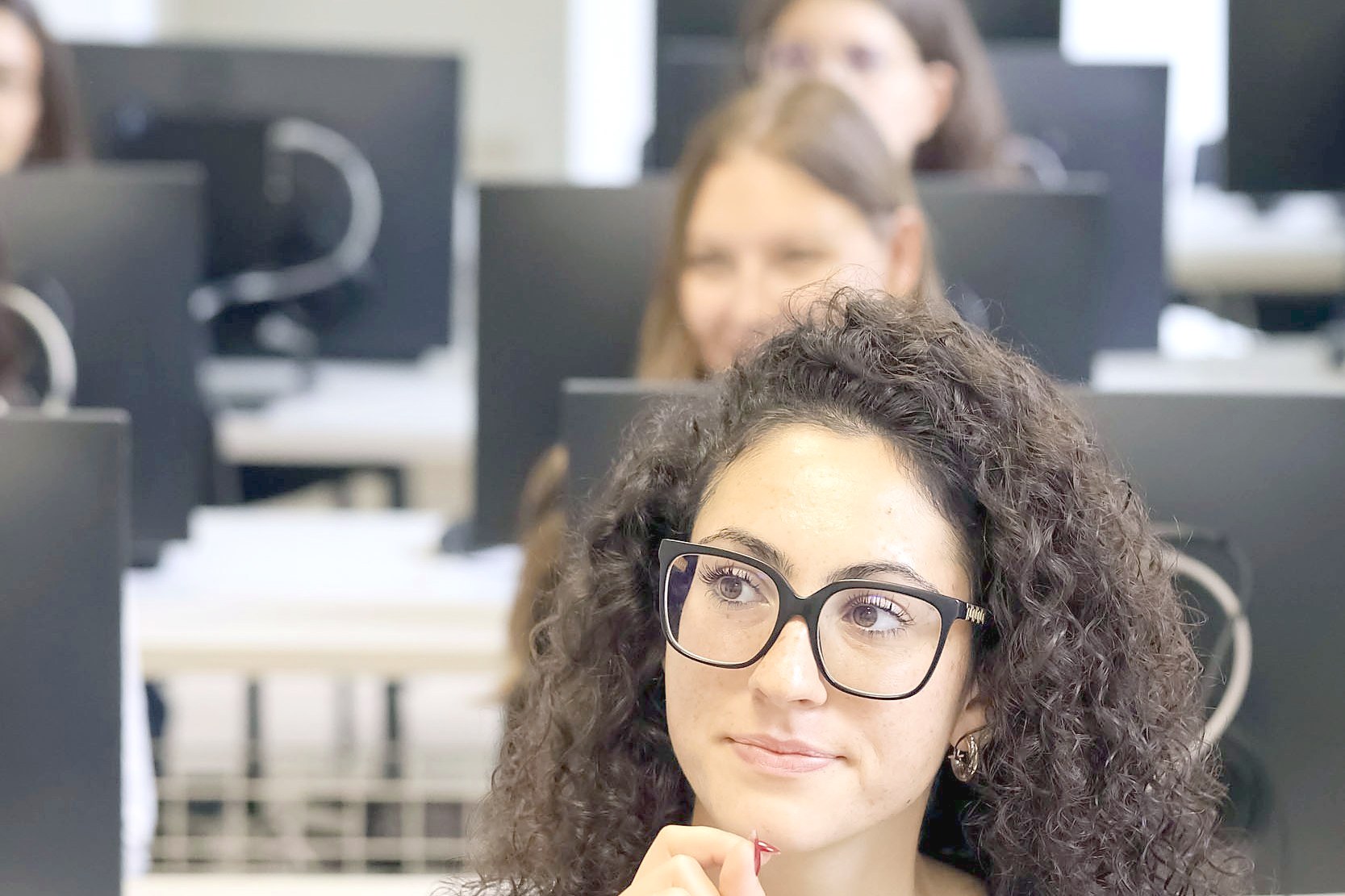 A student smiling in the computer laboratory of the Turin campus