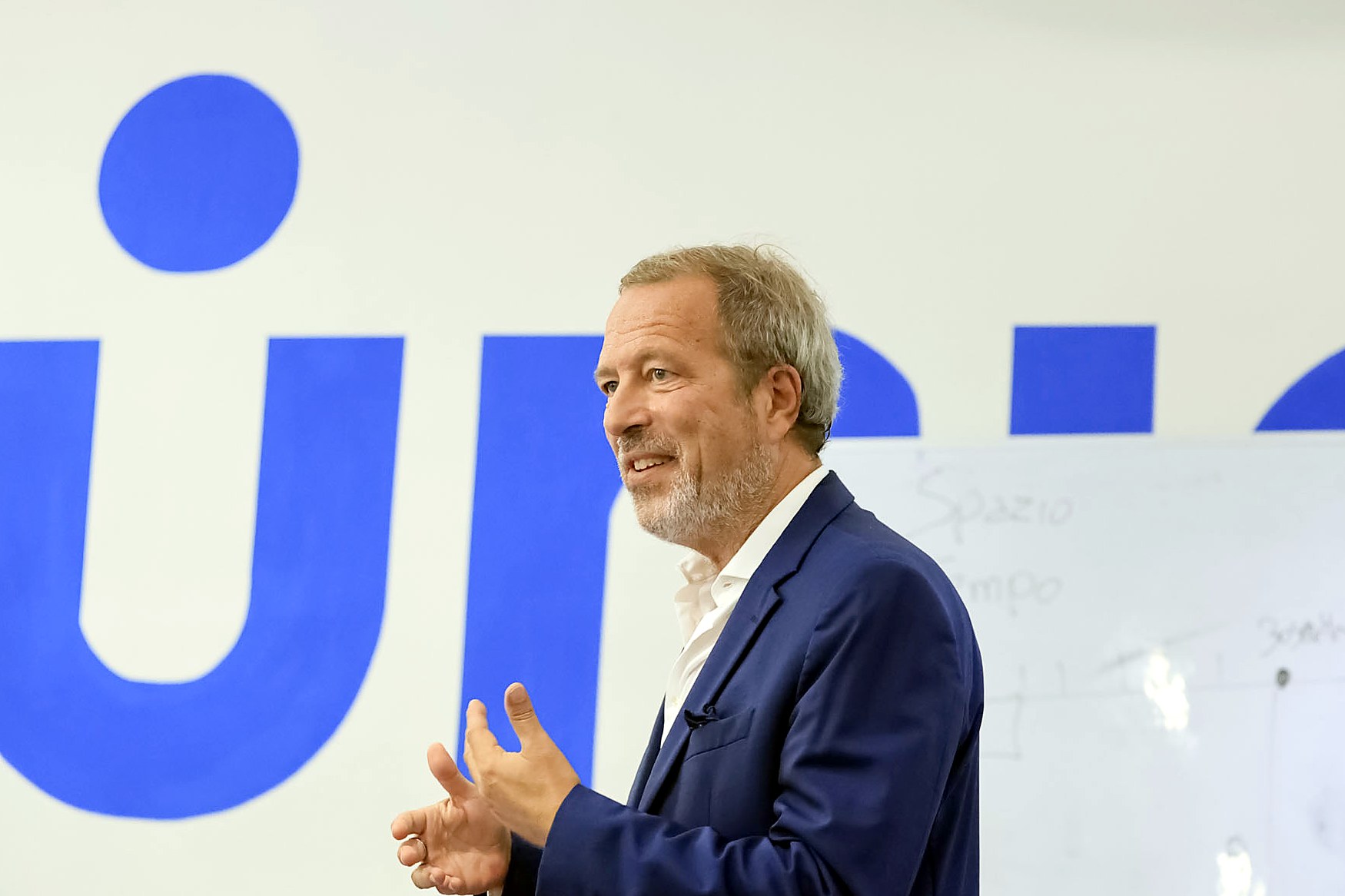 A lecturer speaking in the aula magna of the Turin campus