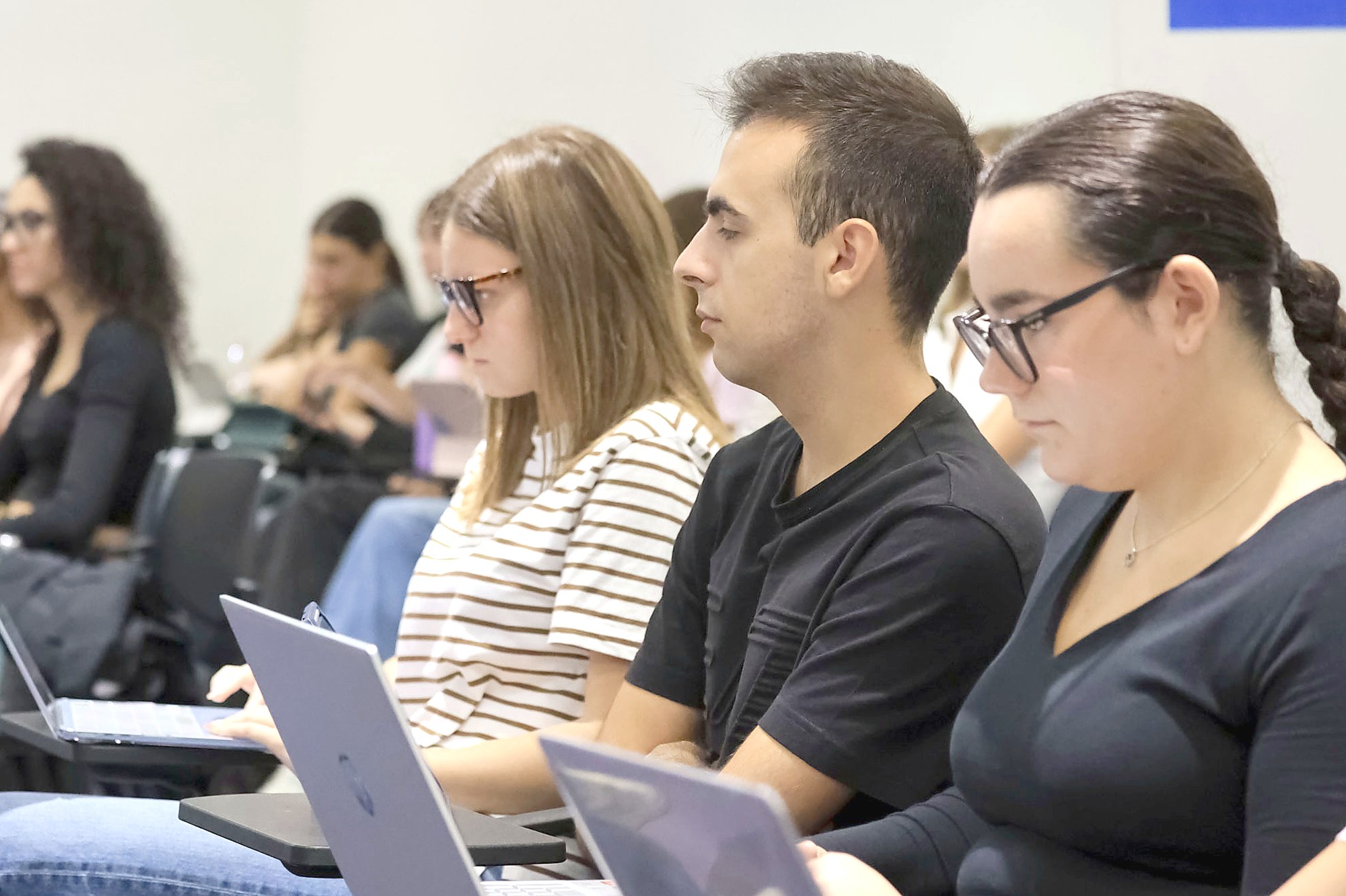 Students taking notes on their laptops during a lecture in Turin