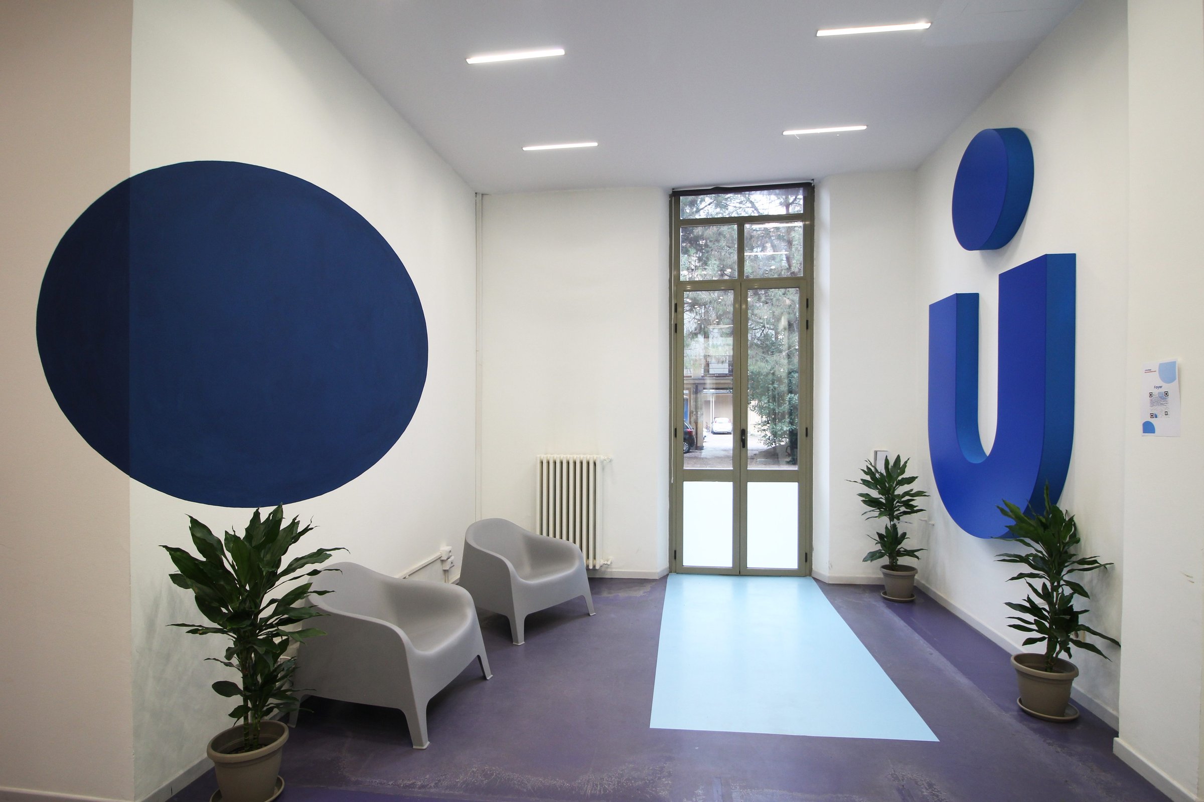 The entrance lounge of the Turin City College with seating and the Unicollege mark