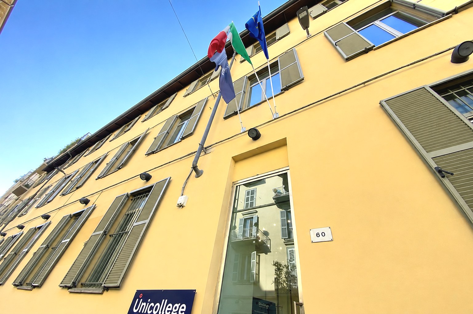 The facade of the Turin City College in Via Saluzzo 60, with the flags above the entrance