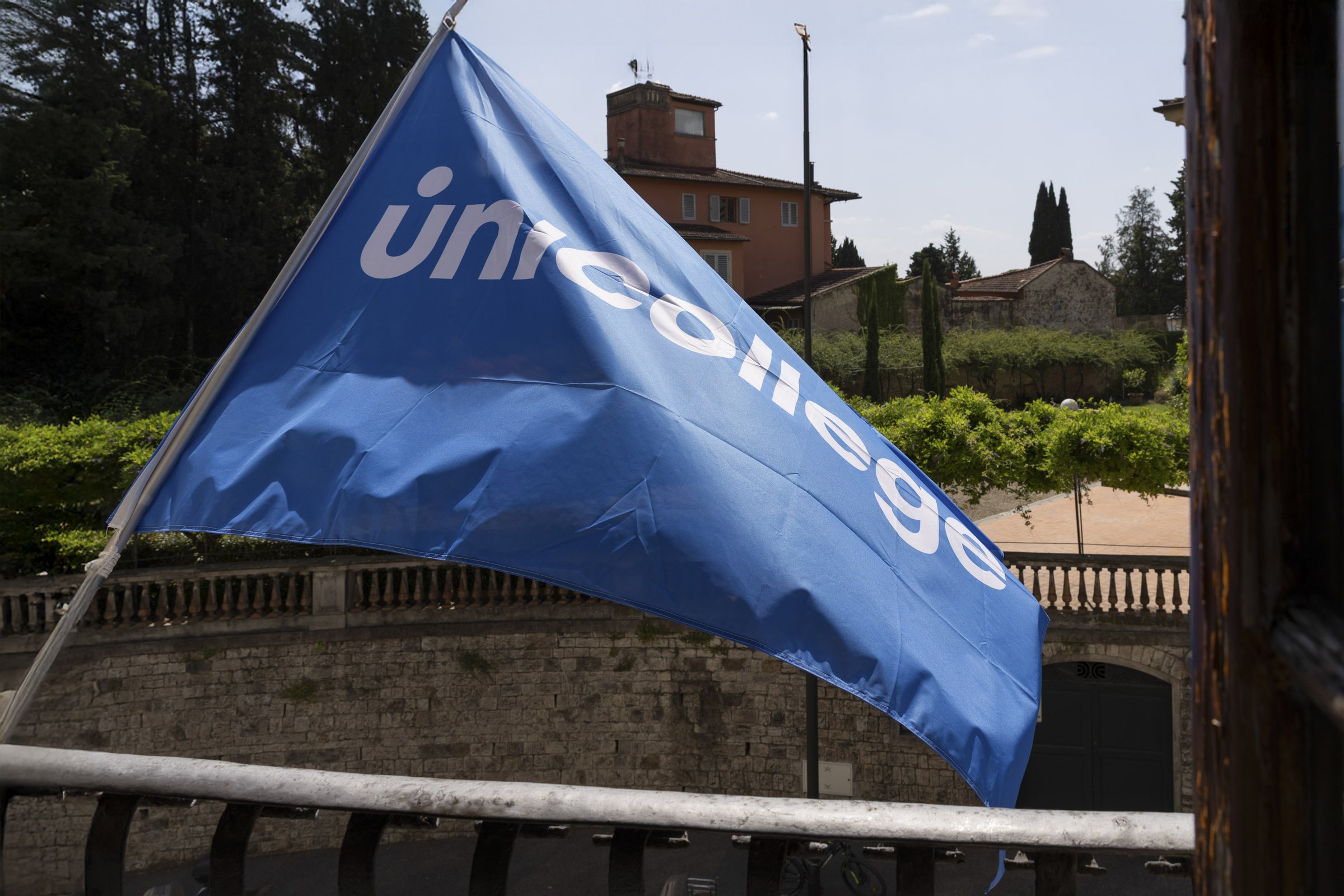 The Unicollege flag flying over the campus grounds