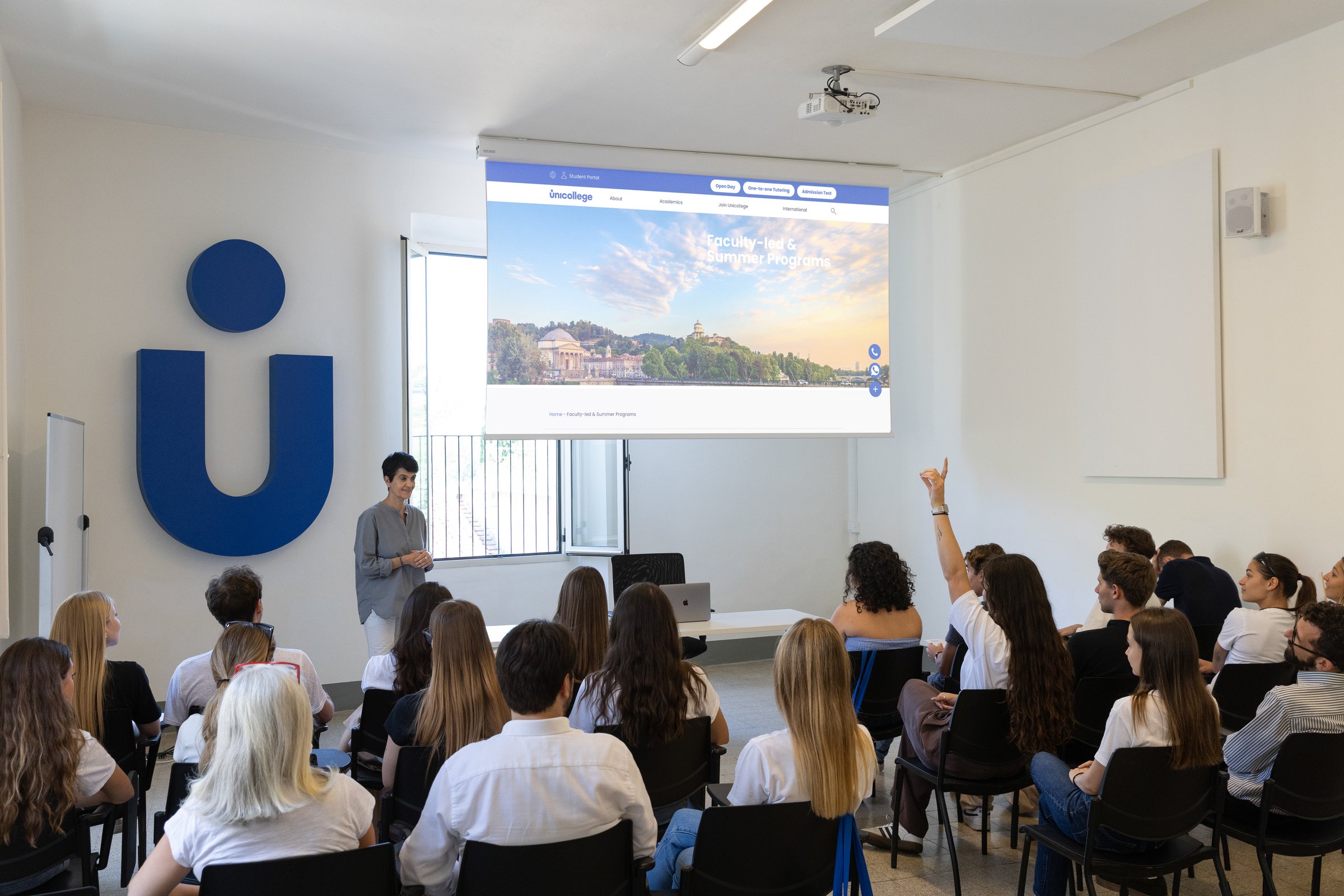 A lecture in a Unicollege classroom, with a student raising her hand