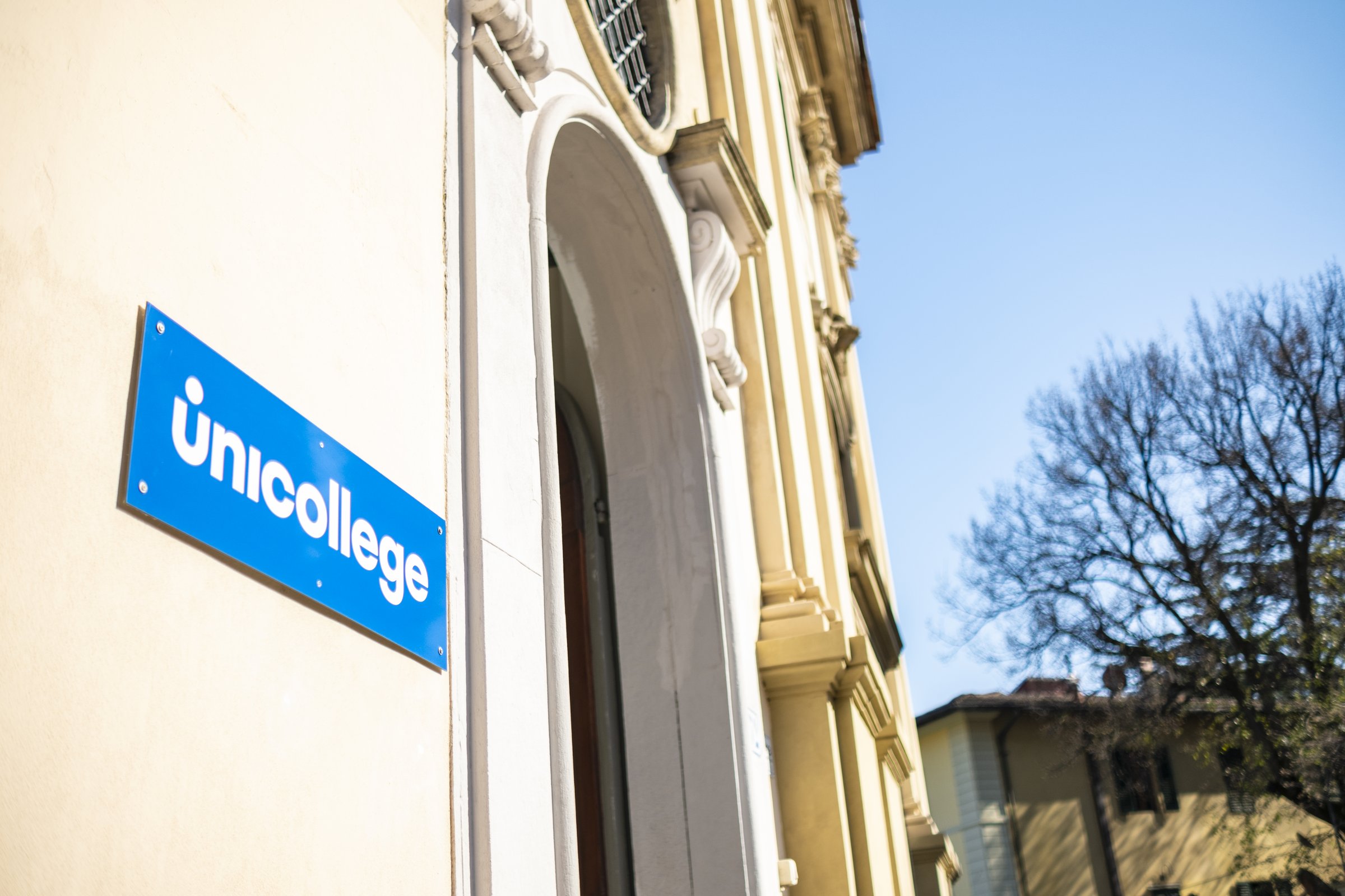 The Unicollege sign beside the arched entrance of a campus building