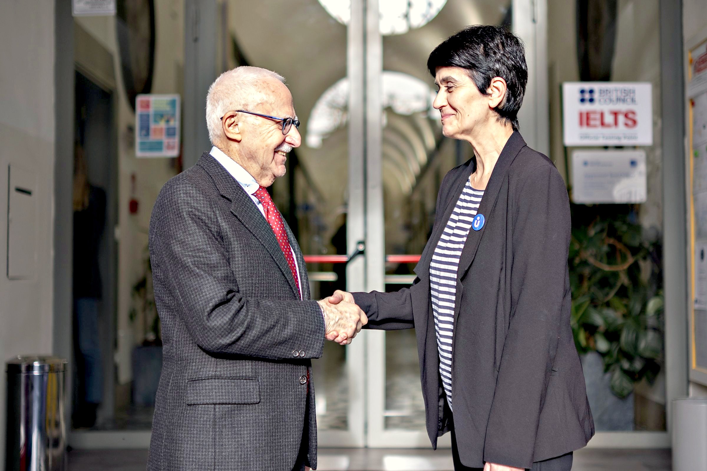 A handshake between the Unicollege president and a partner university representative